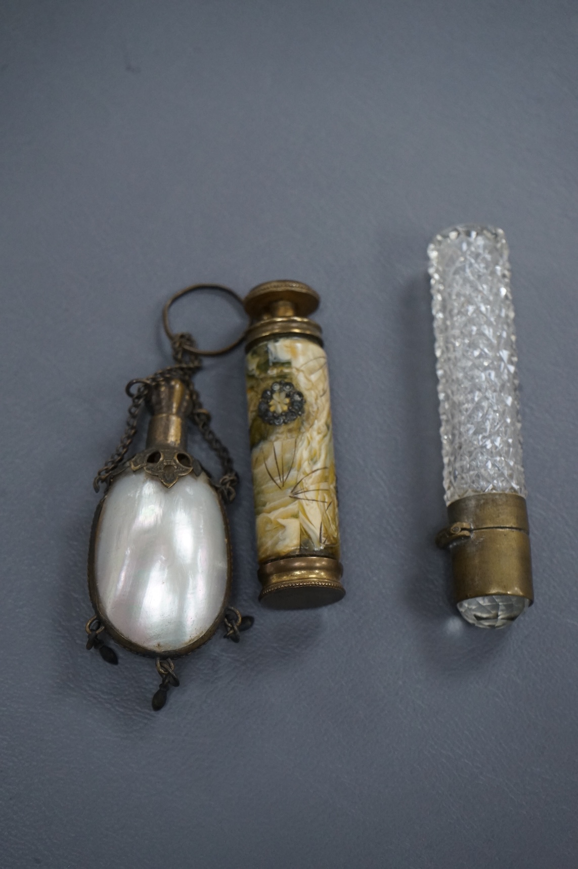 A pump-action scent flask or atomiser and two others, longest 8.5cm